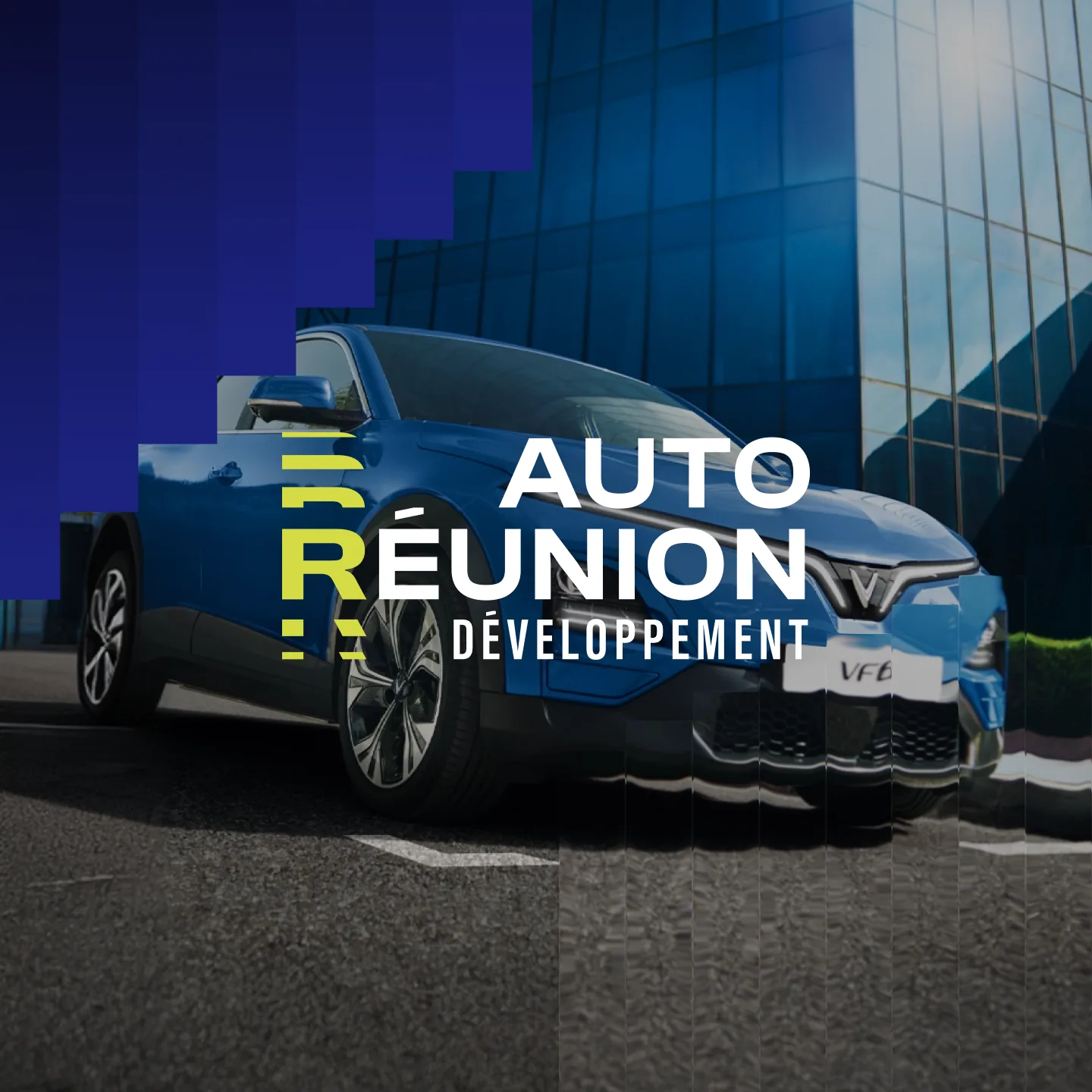 Le logo Auto Réunion Développement sur la photo d’un véhicule bleu, devant un immeuble de verre