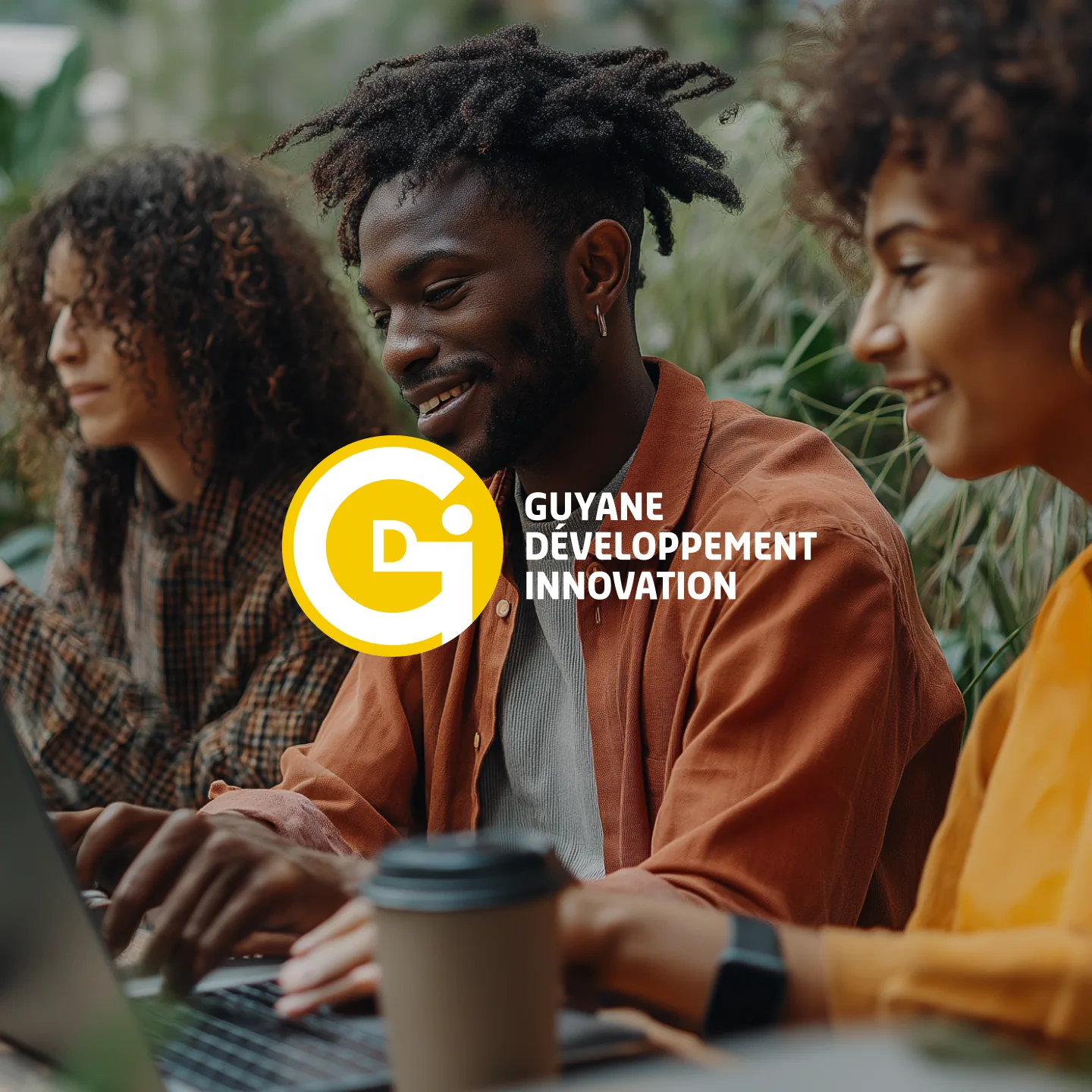 Logo de Guyane Développement Innovation sur une photo de trois jeunes gens au travail devant un ordinateur