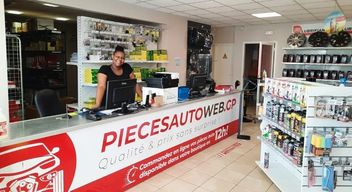 Le magasin Pièces Auto Web en Guadeloupe : le comptoir, son enseigne « Commandez en ligne vos pièces » et les rayons