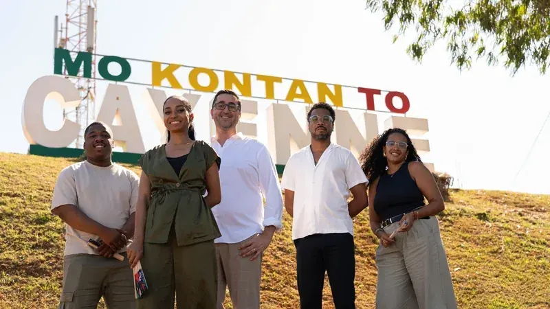 Six membres de l’équipe posent devant les lettres géantes « Mo kontan to Cayenne »